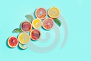 Composition with slices citrus fruits, grapefruit, red orange, lemon, lime on turquoise. Summer food flat lay