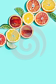 Composition with slices citrus fruits, grapefruit, red orange, lemon, lime on turquoise. Summer food flat lay