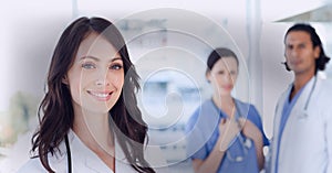 Composition of smiling female doctor in lab coat with stethoscope with vignette