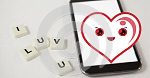 Composition of smiling heart icon over smartphone and i luv u text on white squares