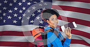 Composition of smiling woman holding passport and ticket, over waving american flag