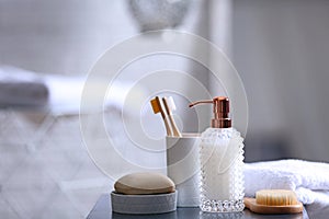 Composition with soap and toiletries on table against blurred background