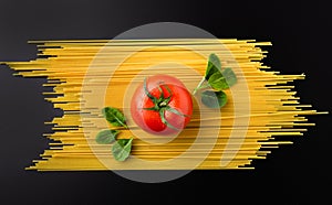 Composition of spaghetti, tomato and spinach on black background. Healthy eating concept. Top view