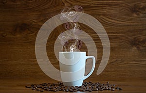 Composition with special effects of cup of hot coffee with coffee beans strayed in it and on the wooden boards