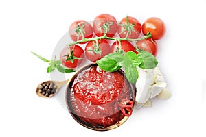 composition of spicy tomato sauce in a wooden bowl with fresh tomatoes, garlic and basil isolated on white background