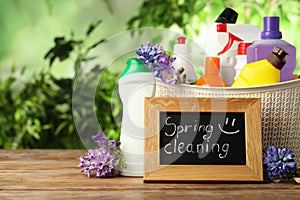 Composition with Spring Cleaning sign, flowers and detergents on table