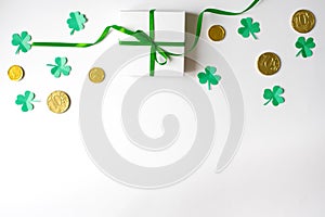 The Composition Of The St. Patrick`s Day. Border made of paper clover leaves, chocolate gold money coins and a gift box