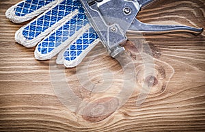 Composition of stapler gun safety gloves on wooden board