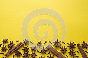 Composition of star anise, cinnamon sticks and cloves on a yellow background. Abstract flat pattern, top view