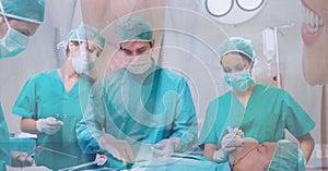 Composition of surgeons in face masks over male patient in operating theatre