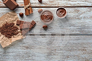 Composition with tasty melted and solid chocolate on wooden background