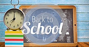 Composition of text back to school in white with clock and chalkboard