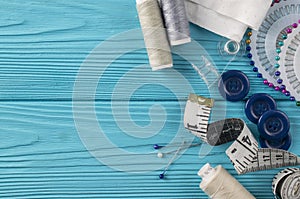 Composition with threads and sewing accessories on blue background