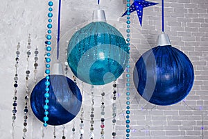 Composition from three blue christmas balls hanging on ribbon,