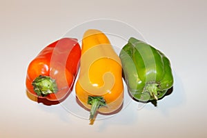 Composition of three peppers: red, yellow, green.