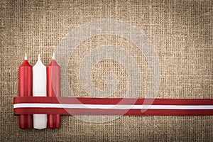 Composition of three red white candles and latvian flag ribbon photo