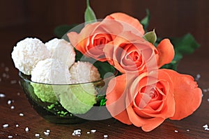 Composition with three roses and candy on dark background