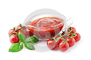 composition of Tomato sauce in a gravy boat with fresh tomatoes and basil isolated