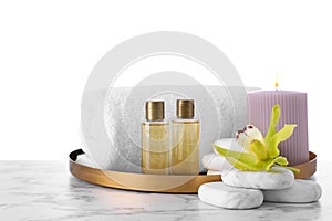 Composition with towel and spa supplies on table against white background