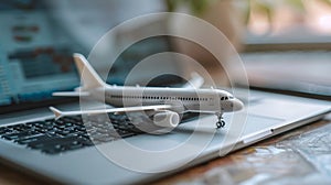 Composition with toy plane and laptop on table. Travel and information Concept. Mini airplane toy model.