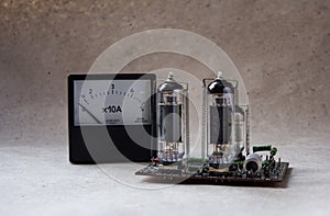 Composition of tube amplifier and vintage ammeter. electronic background.