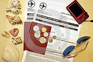 Composition from two passports with air tickets, compact camera, sunglasses, sea shells and foreign coins