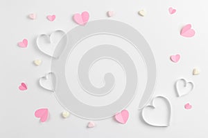 Composition for Valentine`s Day February 14th. Delicate composition of pink hearts made of paper on a white background