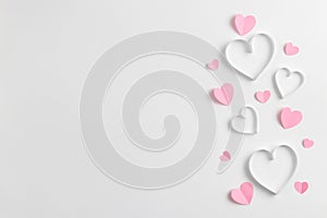 Composition for Valentine`s Day February 14th. Delicate composition of pink hearts made of paper on a white background