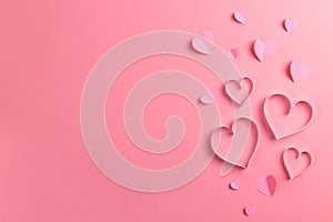 Composition for Valentine`s Day February 14th. Delicate pink background and pink hearts cut out of paper. Greeting card