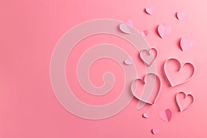 Composition for Valentine`s Day February 14th. Delicate pink background and pink hearts cut out of paper. Greeting card photo