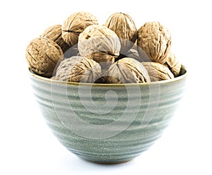 Composition of walnuts in a green cup on a white background