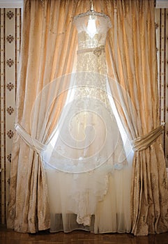 Composition - wedding dress hanging at a wall