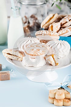 Composition in white and blue with candies, cookies and flower