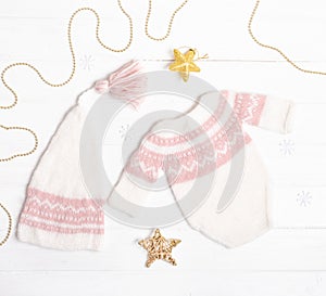 Composition of white-pink knitted suit and hat