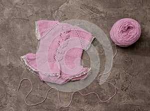 Composition of white-pink knitted suit and hat