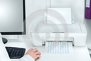 Composition of white printer and black computer