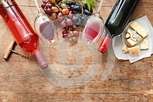 Composition with wine, fresh grapes and cheese on wooden background