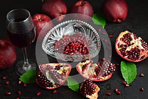 Composition wine glass pomegranates apples leaves on black background