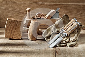 Composition of woodworking tools chisels gloves mallets and woodworkers plane photo