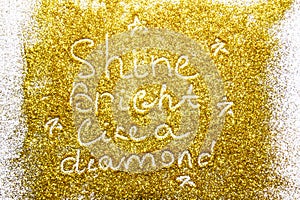 A composition with written a words shine bright like a diamond on beautiful gold glitter. Background and texture of gold glitter.