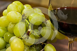 Composition of yellow muscat grape and glass of red wine - close up