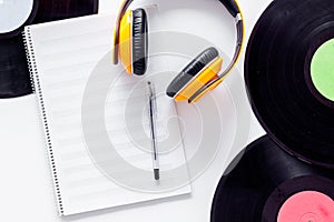 Compositor`s workplace. Vinyl records, headphones, music notes on white background top view