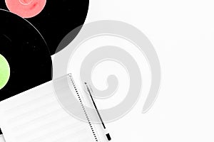 Compositor`s workplace. Vinyl records and music notes on white background top view copyspace