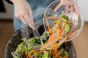 Compost the kitchen waste, recycling, organic meal asian young household woman scraping, throwing food leftovers into the garbage