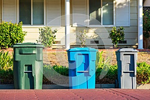 Compost, recycling and garbage carts set outside of the home on the curb for residential garbage and recycling pickup