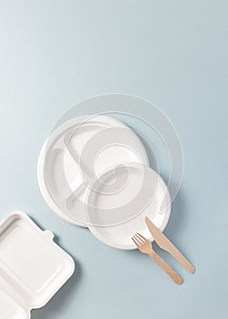 Compostable or biodegradable dinnerware flat lay composition, vertical. Paper plate, food containers, wooden fork, knife