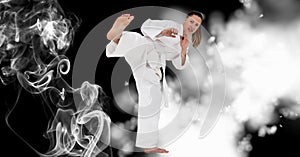 Compostion of caucasian female karate fighter on black background with white blur