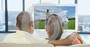 Compostion of couple watching football match on tv at home