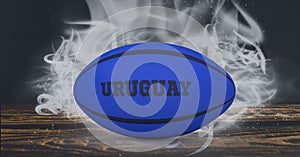 Compostion of rugby ball with text uruguay on black background with white blur