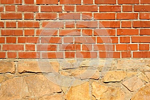 Compound of bricks and rocks in facade. Red brick wall over rock foundation